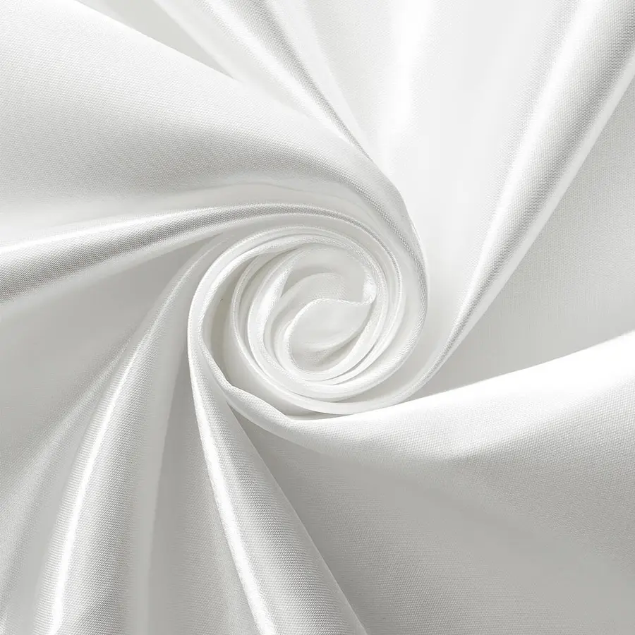 Close-up of smooth white fabric gathered into a spiral, revealing fine weave and varied folds.